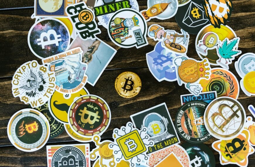 A collection of vibrant Bitcoin-themed stickers and a coin on a wooden surface. Ideal for cryptocurrency concepts.