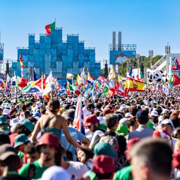 A colorful crowd gathers with flags for a lively celebration in Lisbon.
