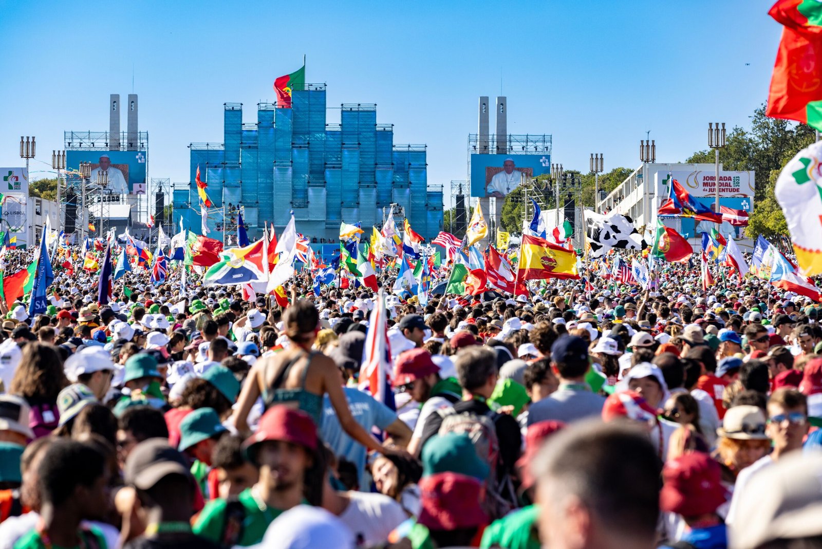 A colorful crowd gathers with flags for a lively celebration in Lisbon.